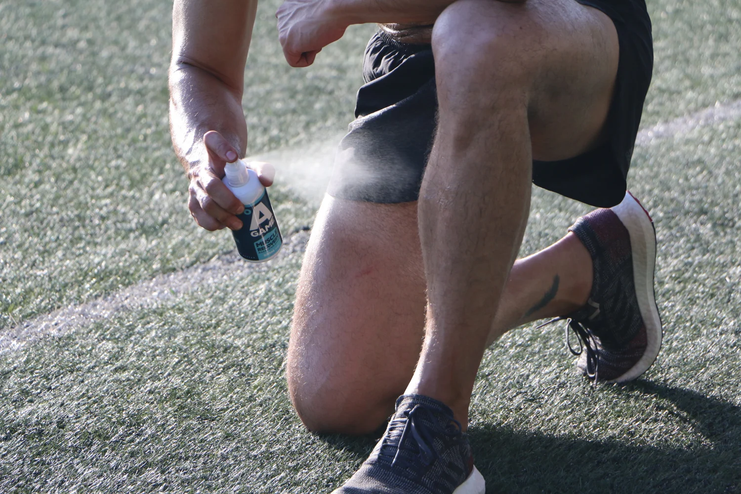 Athlete applying A-Game spray after training